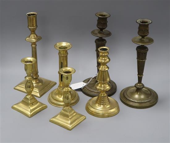 A pair of Empire style candlesticks, another pair and a single